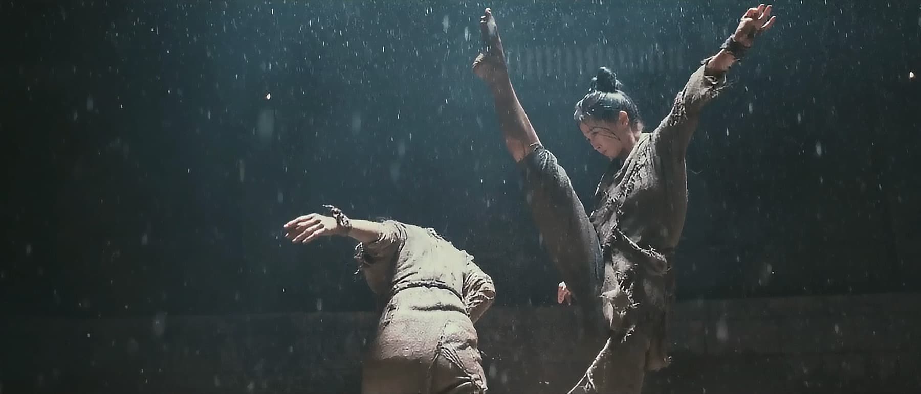 雨の中で跳び蹴りする2人